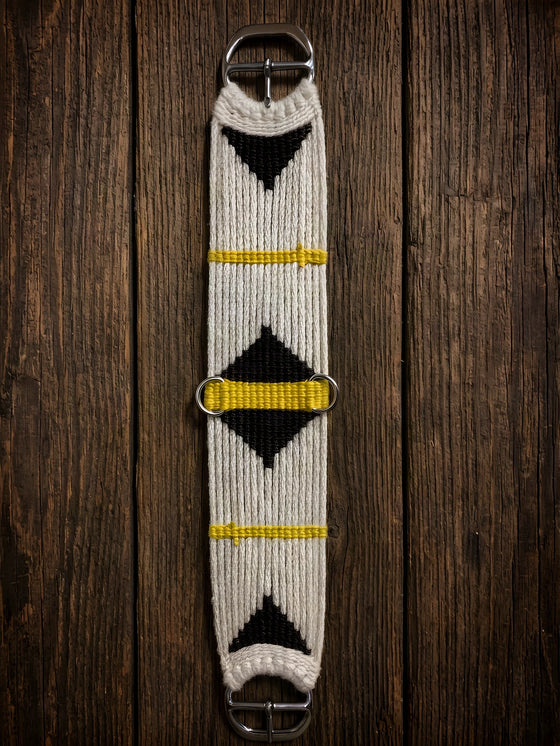 A hand-tied mohair cinch, natural body with dark diamonds and yellow bars, stainless double bar buckles at both ends, on barn wood.
