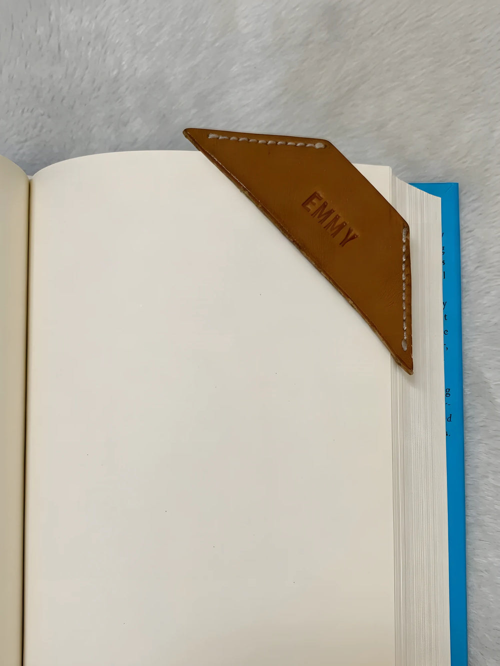 The same leather corner bookmark with a name hand-stamped into it, shown as an example of personalisation.