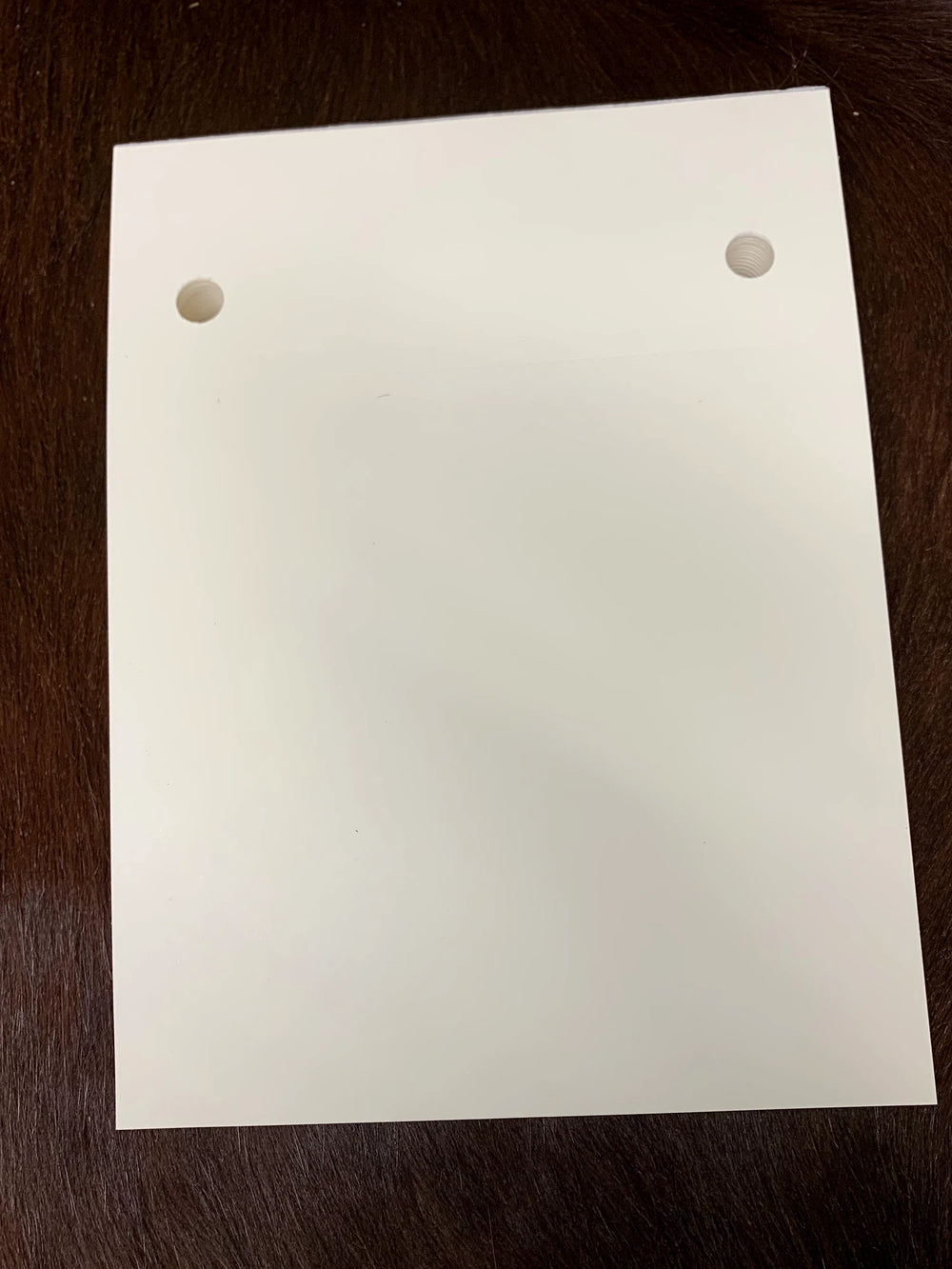A blank 125-page notepad refill pad, punched to fit the B7 notepad cover, on a dark hide.