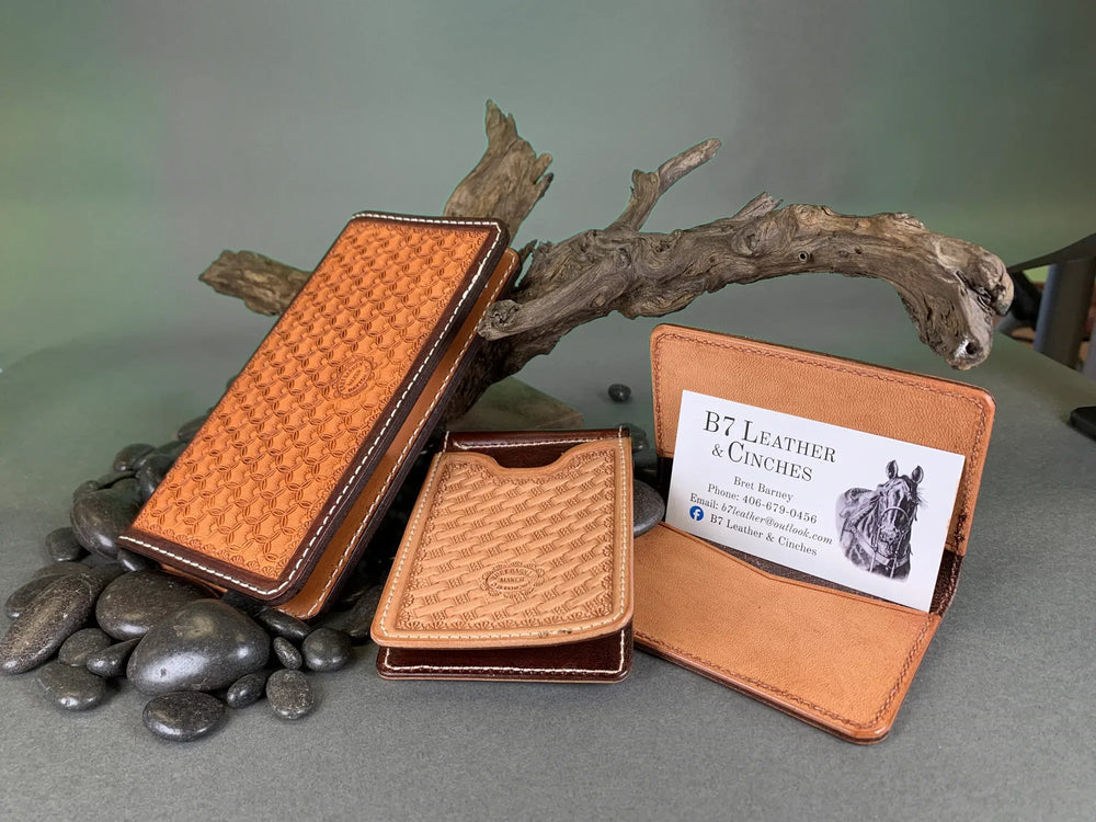 A leather business card case open to show the pockets, with a money clip wallet.
